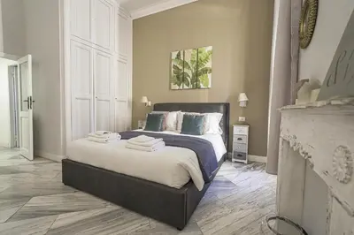 a bedroom with a large bed with blue pillows at SuityRHome RioneMonti37 in Rome