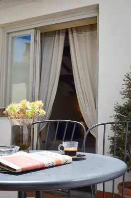 a table and chairs on a patio with a window at Luxury Apartment Pantheon in Rome