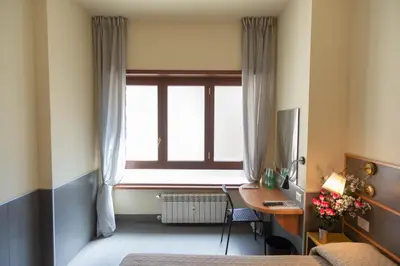 a bedroom with a desk and a window with a computer at tiaspettoaroma in Rome