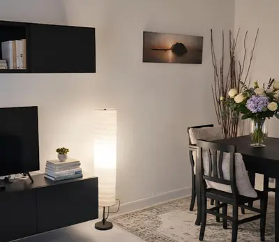 a living room with a dining room table with a television at Vatican Meloria House in Rome