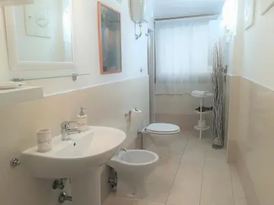 a bedroom with a white cabinet and a chair and a mirror at Vatican Area House in Rome