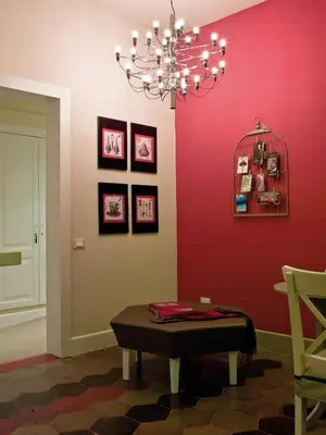 a room with a red wall with a table and a chandelier at Le Stanze Di Orazio in Rome