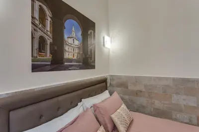 a bed with pillows and a picture of a cathedral at Navona Charme Suite in Rome