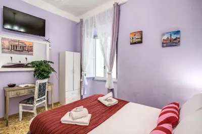 a bedroom with a bed and a desk and a sink at Royal Vatican in Rome