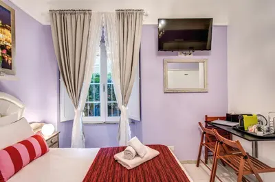 a bedroom with a bed and a desk and a window at Royal Vatican in Rome