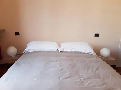 a bed with white sheets and pillows on it at Chiara Rooms in Rome