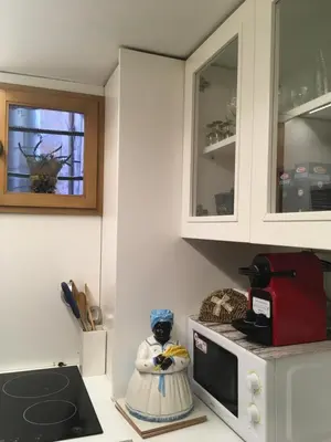 a kitchen with white cabinets and a microwave at Sunny Side Trastevere in Rome