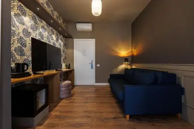 a living room with a blue couch and a tv at Il Corso Comfort Rooms in Rome