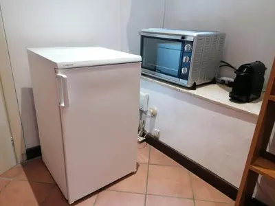 a microwave sitting on a counter next to a refrigerator at Da Adriana al vaticano in Rome