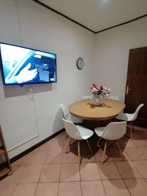 a table with chairs and a television on a wall at Da Adriana al vaticano in Rome