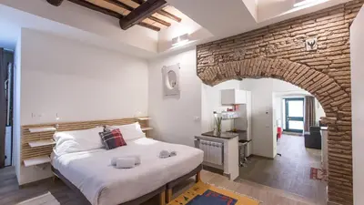 a bedroom with a large bed and a brick wall at Rental in Rome Trastevere White in Rome
