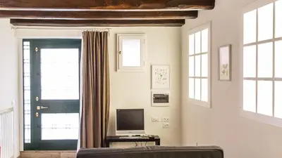 a living room with a couch and a television at Rental in Rome Trastevere White in Rome