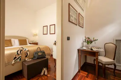 a bedroom with a bed and a table and a chair at Riccardo Condotti Suite in Rome