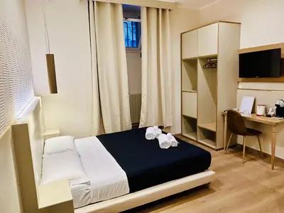 a bedroom with a bed and a desk with a computer at ImeraRooms in Rome