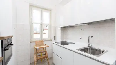 a white kitchen with a sink and a window at Rental in Rome Colosseo View Luxury in Rome