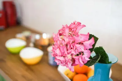 a blue vase filled with pink flowers on a table at Rental in Rome Colosseo View Luxury in Rome