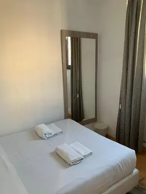 a bed with two towels on it with a mirror at Luciano Laterani Guest House in Rome