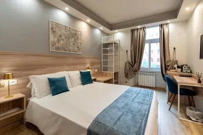 a bedroom with a large white bed with blue pillows at Rome Love Hotel in Rome