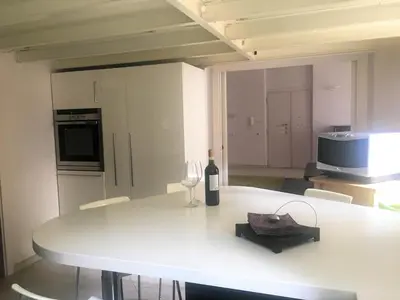 a white kitchen with a table with a bottle of wine at Suite Manzoni in Rome