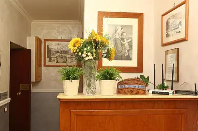 a vase of flowers sitting on top of a dresser at Adorasuite B&B in Rome