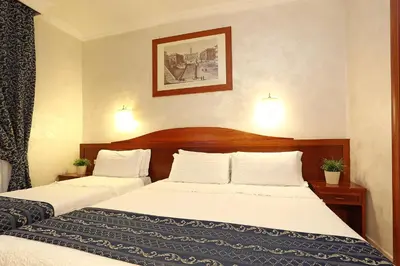 a hotel room with two beds with white sheets at Adorasuite B&B in Rome