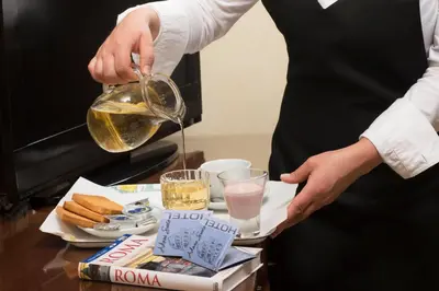 a woman is pouring oil into a table with food at Adorasuite B&B in Rome