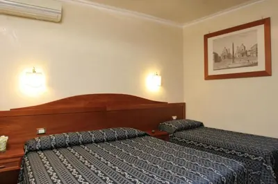 a hotel room with two beds and a picture on the wall at Adorasuite B&B in Rome