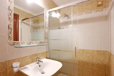 a bathroom with a sink and a glass shower at Adorasuite B&B in Rome
