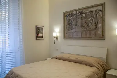 a bedroom with a bed and a painting on the wall at Roma Vespahouse in Rome