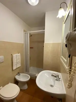 a bathroom with a white toilet and a sink at Hotel Il Papavero in Rome