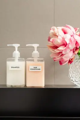 two bottles of soap and a flower on a shelf at Buonanotte Colosseo in Rome