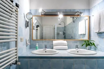 a bathroom with two sinks and a mirror at SmooRoomS Roma Ostiense in Rome