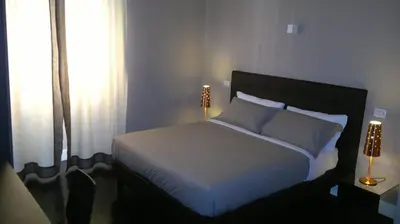 a bedroom with a bed with white sheets and a window at Residence Regola in Rome