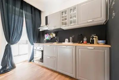 a kitchen with white cabinets and a sink and a window at Be Rome in Rome