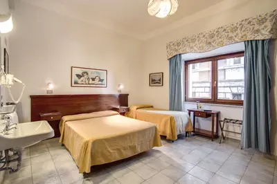 a hotel room with two beds and a sink at Hotel Primavera in Rome