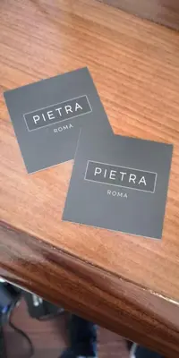 two signs sitting on top of a wooden table at Pietra - The Italian Stay Collection in Rome