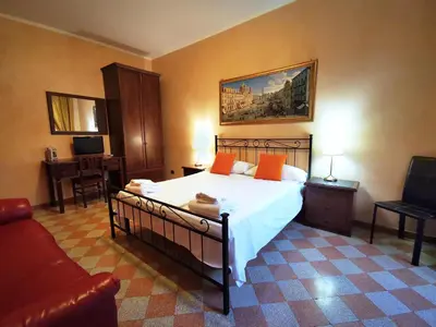 a bedroom with a bed with orange pillows and a couch at Maestoso Locazione Turistica in Rome