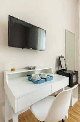 a white desk with a tv and a white chair at Residenza a San Pietro in Rome