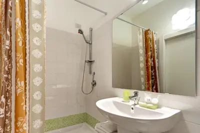 a white bathroom with a sink and a shower at Pianeta Roma 62 in Rome