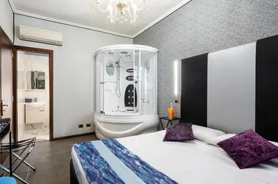 a bedroom with a bed and a chandelier at Hotel Relais Dei Papi in Rome