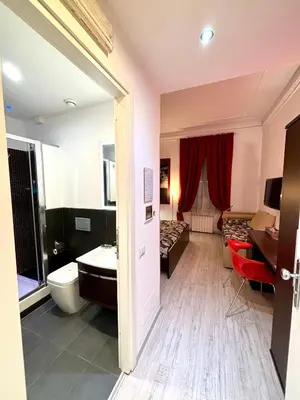 a bathroom with a sink and a toilet and a bed at Chroma Italy - Chroma Tessera in Rome