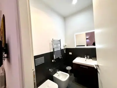 a bathroom with a white toilet and a sink at Chroma Italy - Chroma Tessera in Rome