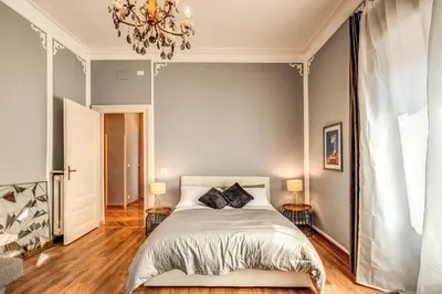 a bedroom with a bed and a chandelier at The Great Retrò in Rome