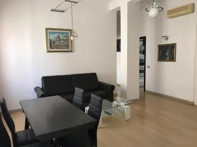 a living room with a table and a black couch at Arches B&B in Rome