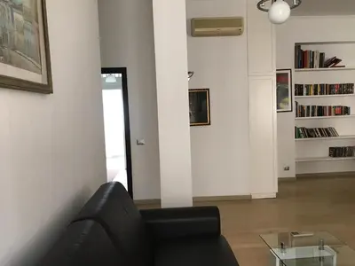 a living room with a black couch and a glass table at Arches B&B in Rome