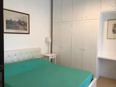 a bedroom with a green bed and white cabinets at Arches B&B in Rome