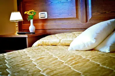 a bedroom with a bed and a vase of flowers on a table at Relais Cavour in Rome
