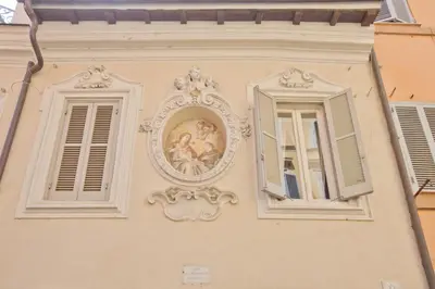 a building with two windows and a painting on it at Il Leopardo (Trastevere) in Rome