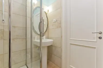 a bathroom with a sink and a glass shower door at Il Leopardo (Trastevere) in Rome