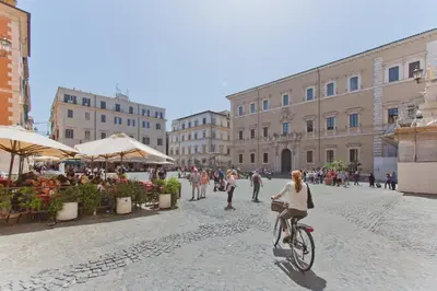 a woman riding a bike down a street at Il Leopardo (Trastevere) in Rome